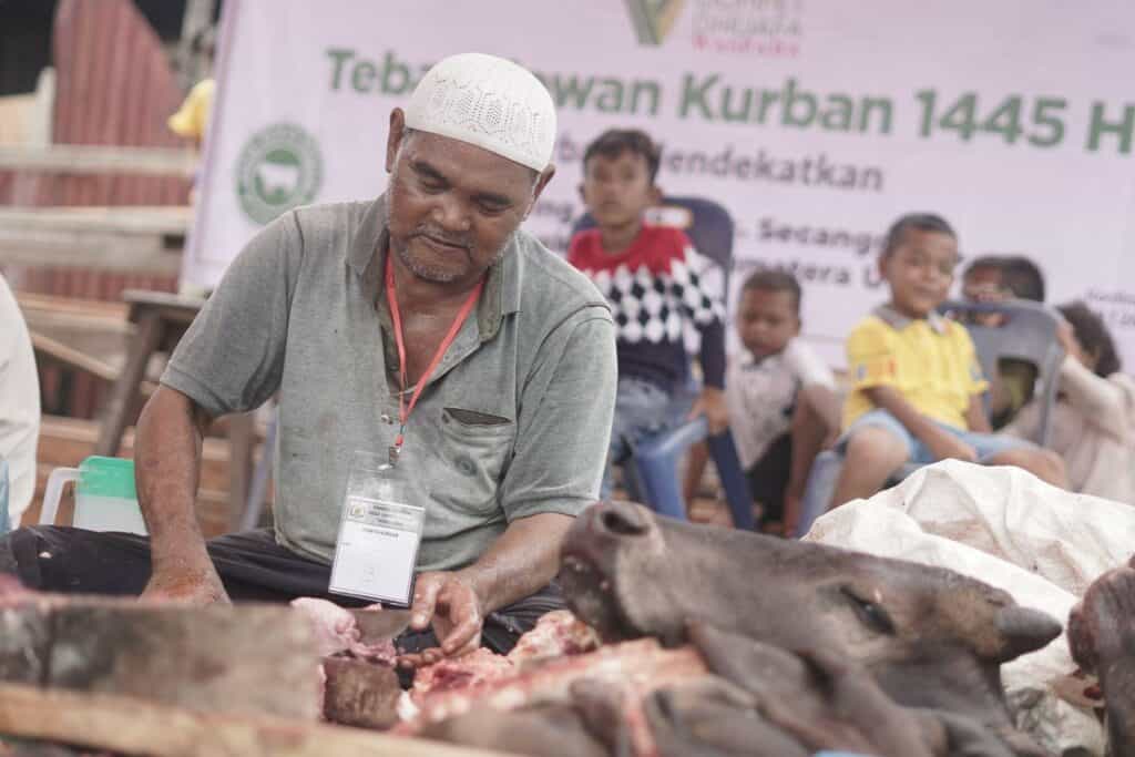 Warga Desa Jaring Halus mencacah-cacah daging kurban dari Dompet Dhuafa untuk dibagikan kepada ke para penerima manfaat.