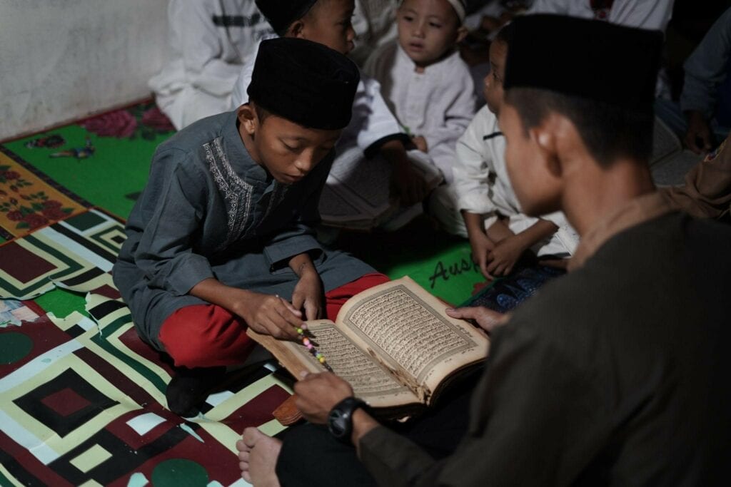 donasi alquran4 dompet dhuafa Seorang santri santri TPA Nurus Salam membaca mushaf Al-Qur'an lama miliknya.