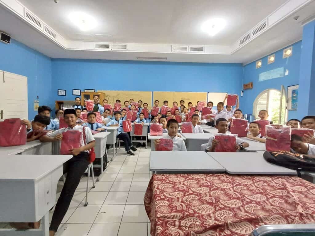 pakaian baru4 dompet dhuafa Para siswa SMART Ekselensia GREAT Edunesia menerima donasi baju berupa kemeja berwarna merah di ruangan kelas mereka, Jum’at (30/08/2024).