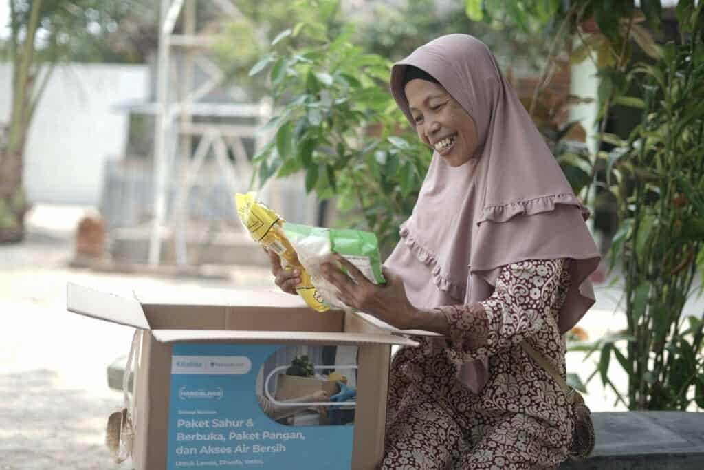 kisah marmiatun3 dompet dhuafa Bahagia Marmiatun dengan antusias membuka bantuan paket sembako yang telah diterimanya.