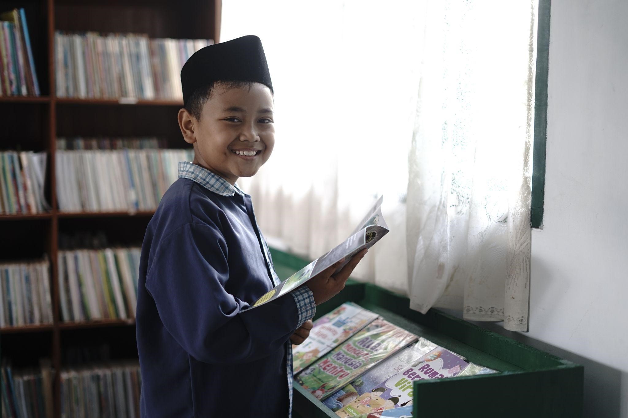 program bersama dompet dhuafa dan ok oce12 dompet dhuafa Abizar salah satu siswa kelas empat SD Negeri 1 Darma saat membaca di Pojok Baca.