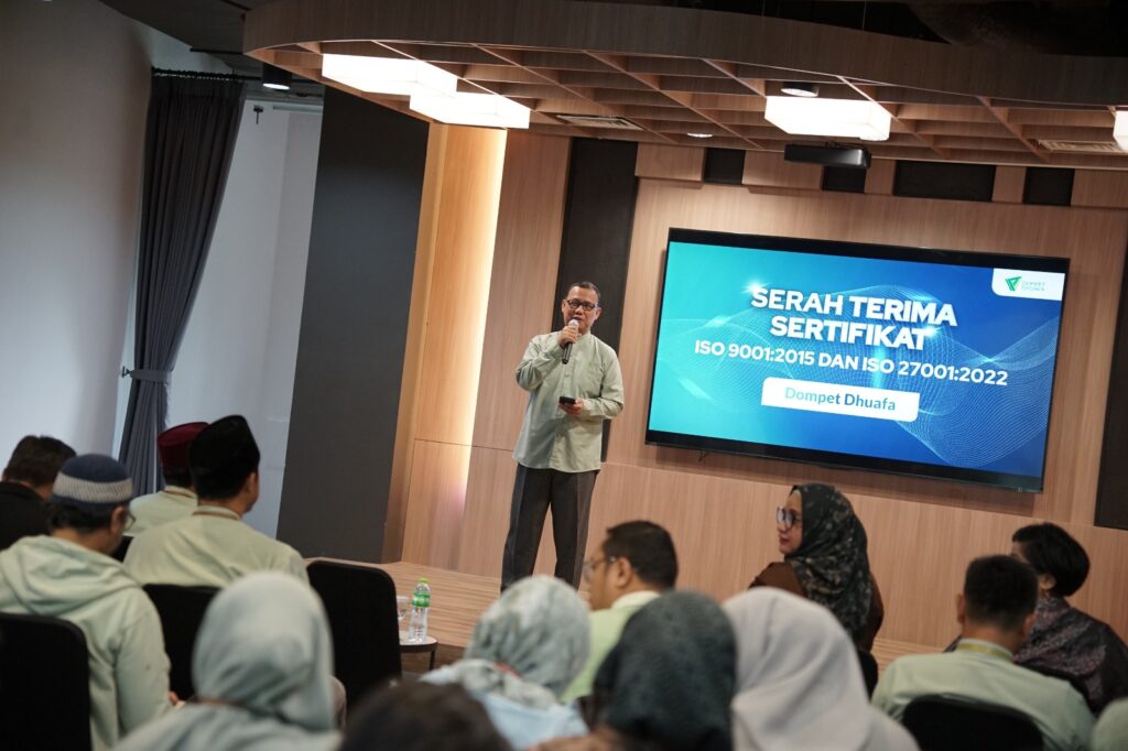 whatsapp image 20250121 at 201457 1 dompet dhuafa Ketua Pengurus Dompet Dhuafa, Ahmad Juwaini, memberi sambutan dalam acara serah terima sertifikasi ISO 9001:2015 dan ISO 27000:2022 sekaligus kick off meeting yang berlangsung di Ruang Sasana Budaya Rumah Kita, Philanthropy Building, Jakarta Selatan, Selasa (21/01/2025) pagi.