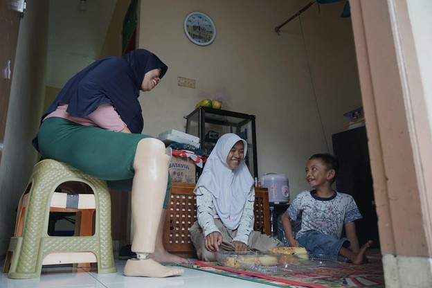 bantuan kaki palsu2 dompet dhuafa Marliyani bersama anak pertamanya, Sharah dan anak keduanya, Iqbal yang juga penyandang disabilitas, sedang menyiapkan pesanan catering di kediamannya, Beji, Depok, Jawa Barat.