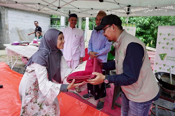Ketua Ramadhan 1446 H Dompet Dhuafa (kanan) membagikan bantuan bantuan mukena dan alat sholat di Kampung Bambon, Jagakarsa, Jakarta Selatan, Sabtu (15/03/2025).