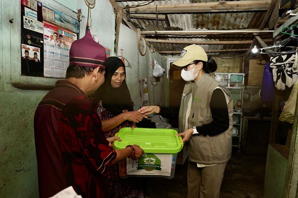 Rumah ke rumah, Marcella Zalianty (kanan) dan Bang Qubil (kiri), membagikan bantuan sembako di Kampung Bambon, Jagakarsa, Jakarta Selatan, Sabtu (15/03/2025).