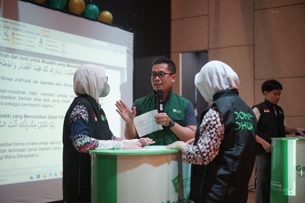 Di atas panggung teater, Yudha mendampingi para siswa praktik menjadi Amil dan Muzaki serta menghafal do’a untuk Muzaki yang telah berzakat.