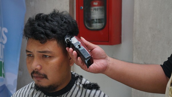 Pos Mudik Ramah Keluarga menghadirkan layanan potong rambut gratis.
