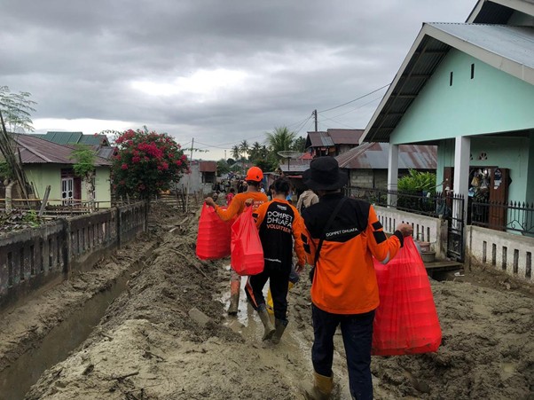 DMC Dompet Dhuafa membagikan makanan kepada warga penyintas banjir di Desa Wombo pada Minggu.