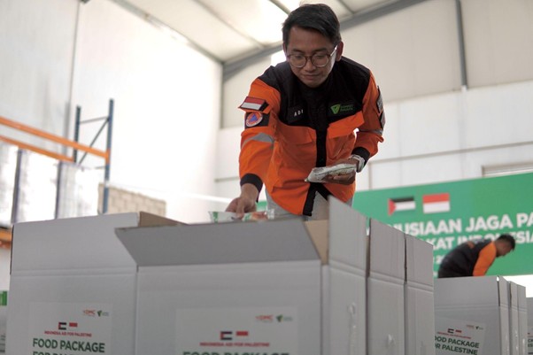 gudang logistik untuk palestina di yordan3 dompet dhuafa Adi Kurniawan, salah satu dari tim kemanusiaan Dompet Dhuafa melakukan pengemasan paket bantuan untuk didistribusikan menuju wilayah Gaza.