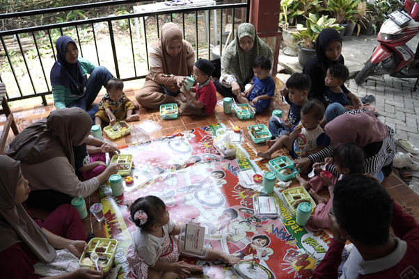 implementasi zakat dari humia trust2 dompet dhuafa Para ibu dan balita sedang menyantap bersama masakan yang dimasak bersama antara kader dan orangtua di Posyandu Mawar, Kelurahan Mangempang, Kabupaten Barru.