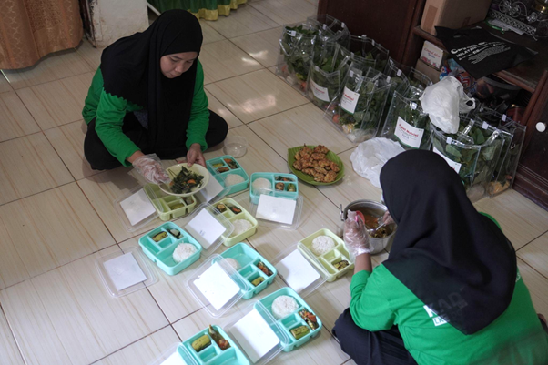 implementasi zakat dari humia trust5 dompet dhuafa Kader Posyandu Mawar sedang menyajikan makanan dalam wadah yang akan dibagikan ke balita yang ada di Posyandu Mawar, Kelurahan Mangempang, Kabupaten Barru.