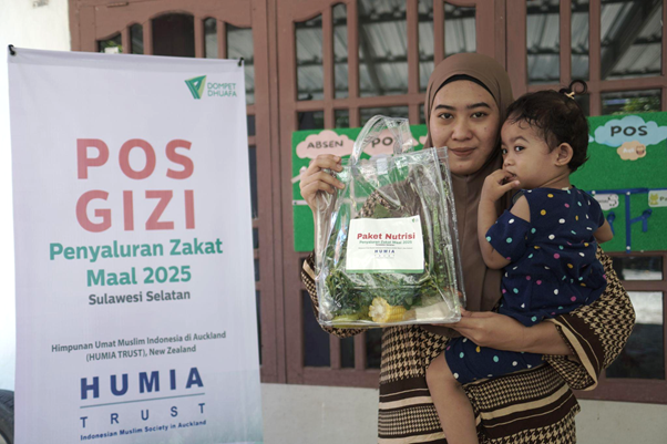 implementasi zakat dari humia trust6 dompet dhuafa Seorang ibu menggendong balita menunjukan paket nutrisi yang didapatkan dari program Pos Gizi di Posyandu Mawar, Kelurahan Mangempang, Kabupaten Barru, Sulawesi Selatan.