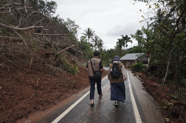 Tim Medis melewati titik longsor untuk mencapai rumah pasien lansia di Tantaman, Palembayan.