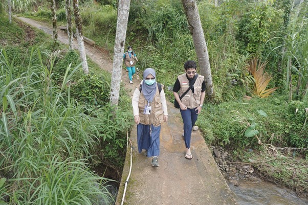 Tim Medis melewati titik longsor untuk mencapai rumah pasien lansia di Tantaman, Palembayan.