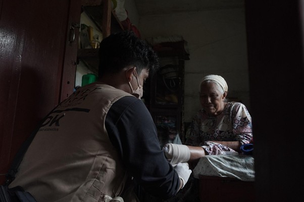 dr. Kenni memberikan perawatan luka pada pasien lansia yang kesulitan akses pelayanan medis di Tantaman, Agam.
