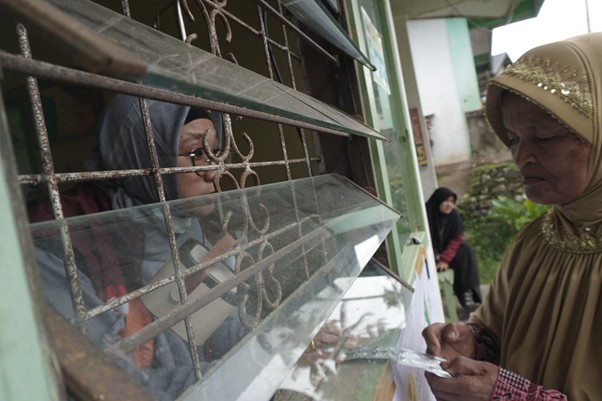 Apoteker memberikan obat resep untuk pasien di Pos Medis.