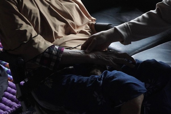 Dokter memeriksa kondisi medis lansia yang duduk di kursi roda.