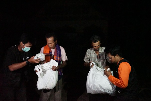 Relawan Dompet Dhuafa membagikan makanan kepada warga yang menunggu di pinggir-pinggir jalan Tamiang.