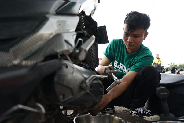 mimpi alumni institut kemandirian punya bengkel motor sendiri2 dompet dhuafa Eka memeriksa kondisi motor milik salah satu pengemudi ojol penerima manfaat program BEROJOL Dompet Dhuafa.
