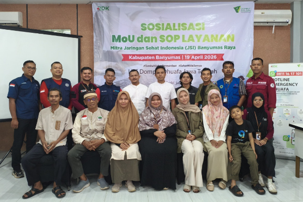 fotojet 3 dompet dhuafa Group of men and women posing for a photo at a health outreach event in front of a banner reading'SOSIALISASI MoU dan SOP LAYANAN' in Banyumas, 19 April 2026.