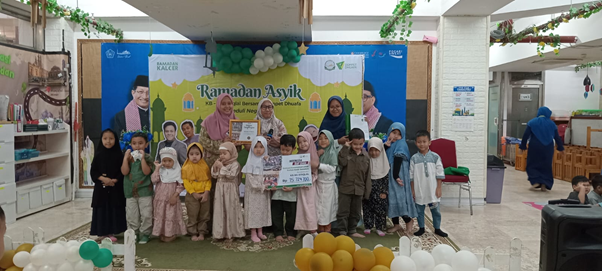 ramadan asyik kb ra istiqlal 1 dompet dhuafa Group of children posing on a stage in front of a Ramadan banner at a community event.