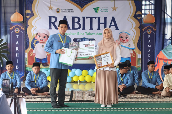 sumatera bangkit 1 dompet dhuafa Man and woman on stage holding awards and a certificate at a Rabitha event, with students in blue shirts seated behind.