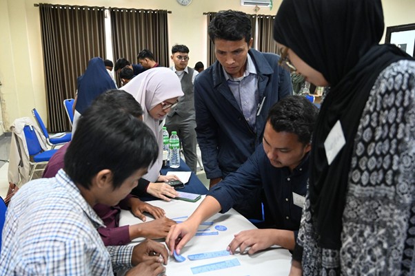training of trainer ik dd 1 dompet dhuafa Group of diverse students around a table collaborating on a workshop activity with blue index cards on the surface.