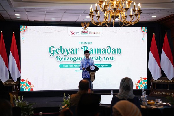 dampakzakatroisojkdandompetdhuafa20266 dompet dhuafa Speaker on stage at the Penutupan Gebyar Ramadhan Keuangan Syariah 2026 event, with a large screen behind him displaying the title and Indonesian flags on both sides.
