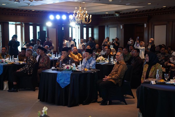 dampakzakatroisojkdandompetdhuafa20267 dompet dhuafa Formal banquet: attendees in traditional attire sit at round tables in a dimly lit conference hall with chandeliers overhead.