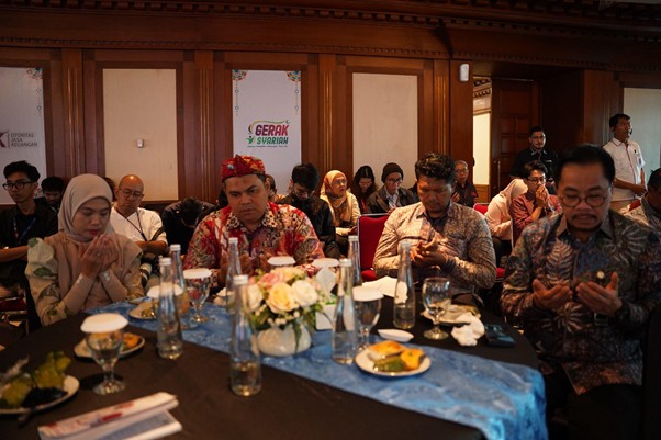 dampakzakatroisojkdandompetdhuafa20268 dompet dhuafa Diverse group of people seated around a banquet table at a formal event, with flowers, plates, and beverages; audience in the background.