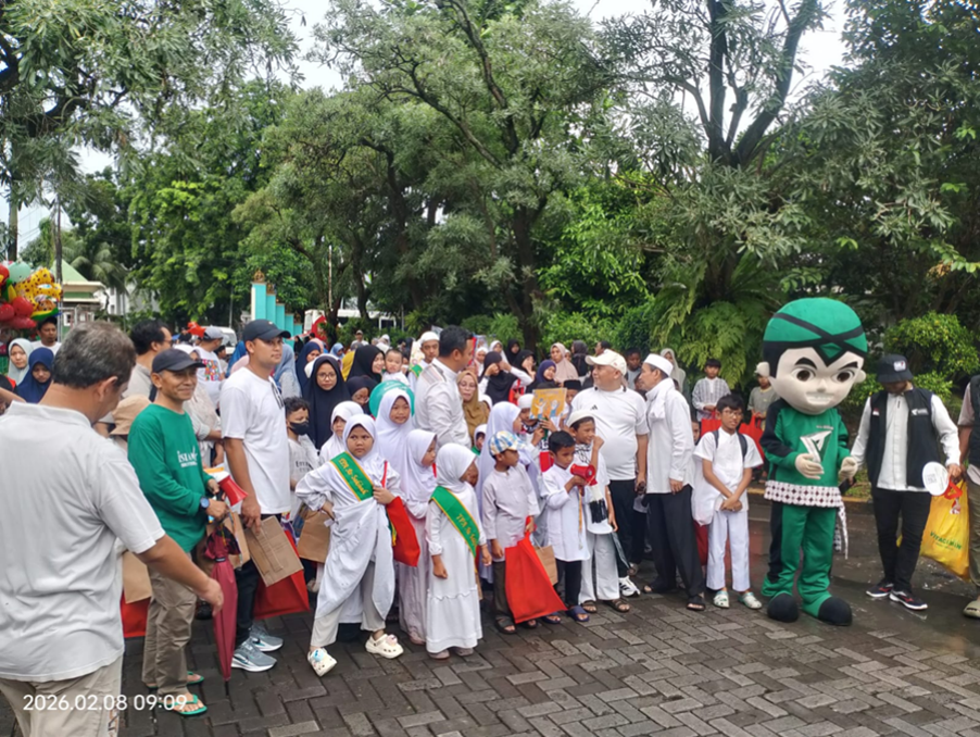 donasifiber2 dompet dhuafa Group of children in white robes with green sashes at an outdoor event, posing with a green mascot in a park.
