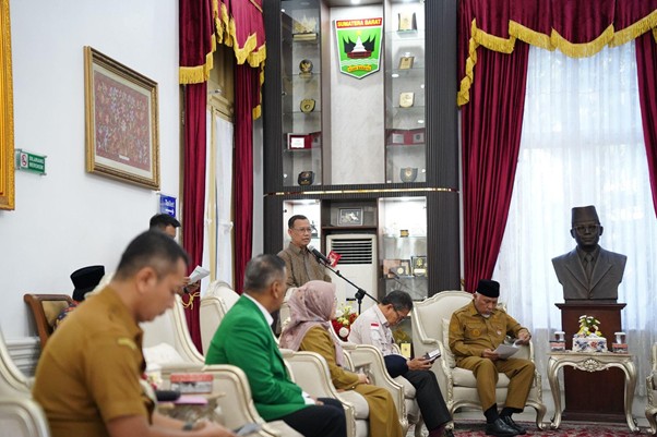 pemprovsumaterabarat3 dompet dhuafa Officials seated in a formal government chamber listening to a speaker at a podium; crest, bust statue, and red drapes in the background.
