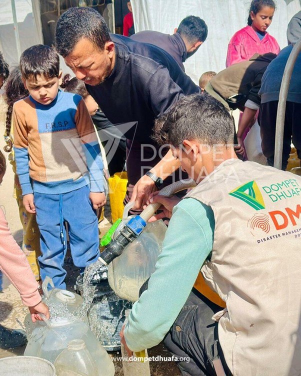 Relief worker fills water containers for children at a disaster relief site.