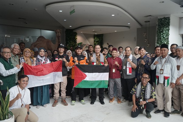 tim kemanusiaan gaza ke mesir 1 dompet dhuafa Group of people indoors posing for a photo, holding Indonesian and Palestinian flags in a show of solidarity.