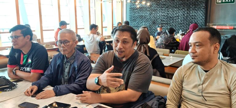 whatsappimage20260419at184751768x352 dompet dhuafa Group of four men seated at a cafe table; the center man speaks with a hand gesture while others listen.