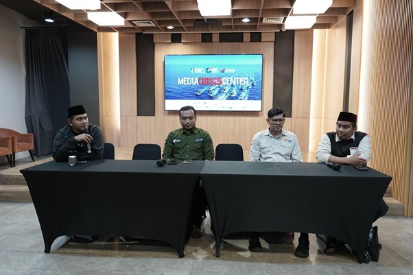 media crisis center gpci dompet dhuafa Panel discussion at a media crisis center: four men seated behind a long black table, with a 'Media Crisis Center' display on the wall behind them.