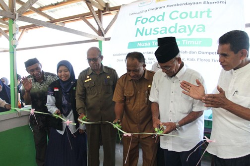 nusadayantt5 dompet dhuafa Group of people in uniforms and traditional clothing cutting a green ribbon at a Food Court Nusadaya opening event, with a banner in the background.