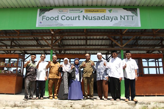 nusadayantt6 dompet dhuafa Group of ten people posing in front of the 'Food Court Nusadaya NTT' sign on a green building exterior.