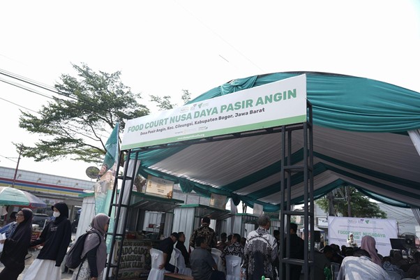 foodcourt nusadaya bogor 11 dompet dhuafa Outdoor food court stall with green-and-white banner reading 'Food Court Nusa Daya Pasir Angin', people queueing under a canopy in a market area.