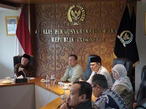 gpcikempr2 dompet dhuafa Officials in a formal meeting around a wooden conference table in an Indonesian government room.