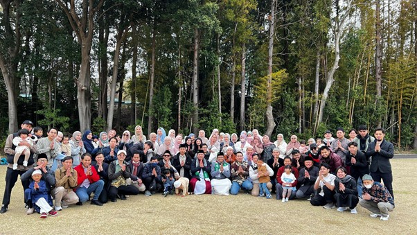iduladha jepang 3 dompet dhuafa Large diverse group posing for a group photo outdoors on a grassy field with trees behind them.