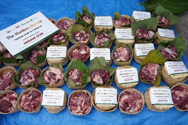 kurbanroisojk7 dompet dhuafa Row of small woven baskets filled with raw meat chunks, each with a label from The Kurban Series on a blue tarp background.