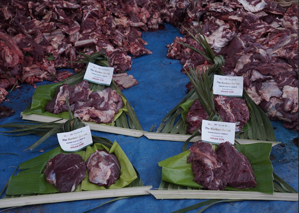 kurban rois ojk 9 dompet dhuafa Rows of raw meat cuts placed on banana leaves on a blue tarp, each with small white labeling cards nearby for display
