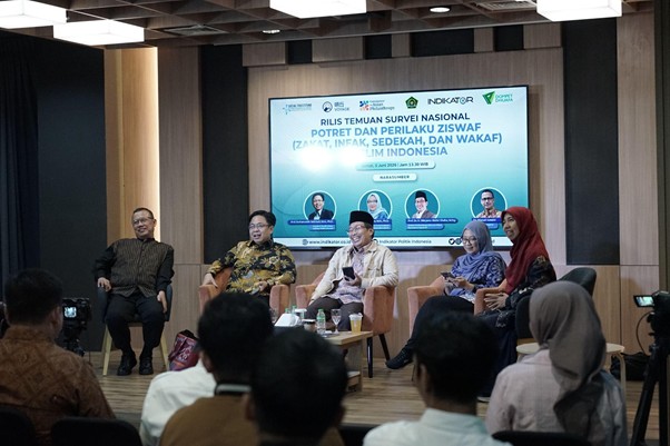 Six-panel discussion on stage in a conference room; audience watching, banner behind with Indonesian national survey text.