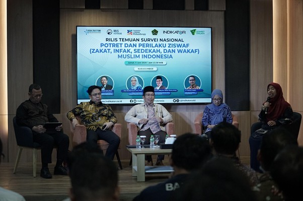 Panel discussion on stage with five speakers; banner behind discusses a national survey on charitable giving in Indonesia (Zakat, Infak, Sedekah). Audience is seated in front.
