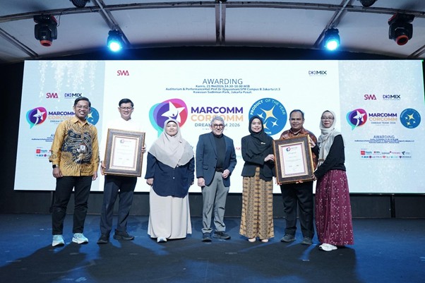 Seven people on a stage holding framed awards at a MARCOMM Conference awards ceremony, with logos displayed on a large screen behind them.
