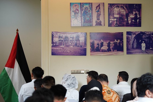 peringatanharinakbake7810 dompet dhuafa Group of people seated facing a wall with framed photos, Palestinian flag visible on the left.