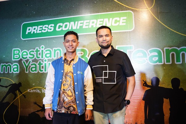 Two men stand together in front of a 'PRESS CONFERENCE' banner at an event, posing for a photo.