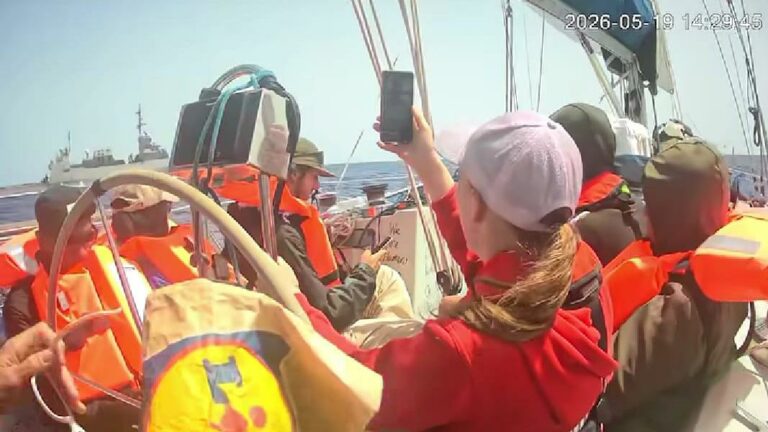 whatsappimage20260520at181358768x432 dompet dhuafa People in orange life jackets aboard a sailboat at sea; a woman in a red jacket and white cap raises a smartphone to take a photo.