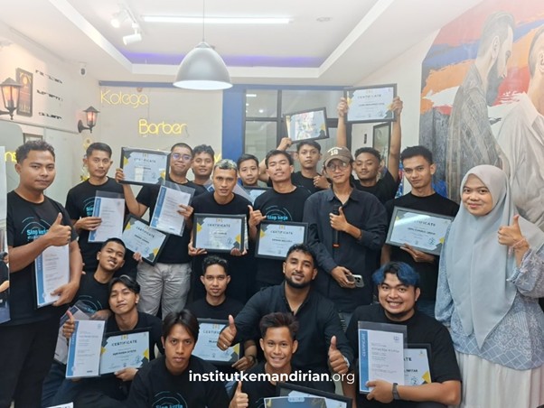industri barber institut kemandirian 6 dompet dhuafa Group of men and women in a classroom proudly holding certificates and giving thumbs up, with a watermark reading institutkemandrian.org at the bottom.